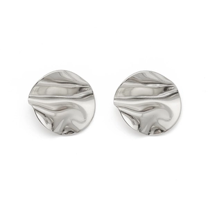 Gros plan sur des boucles d'oreilles géométriques en argent à texture ondulée