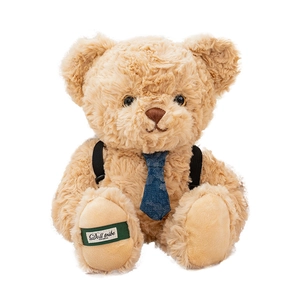Cute light brown teddy bear plush with blue tie and black suspenders on white background