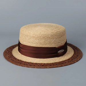 Macro detail of retro flat-top straw hat with two-tone brim and brown satin ribbon