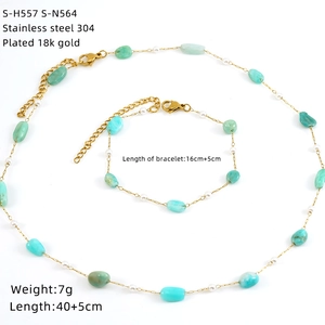 Flat lay of 18k gold plated necklace and bracelet set with turquoise and pearls