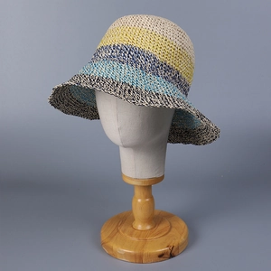 Detail of multi-colored striped straw sun hat on a wooden display stand for women