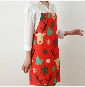 Detail of red Christmas apron with reindeer and snowflake print on a model