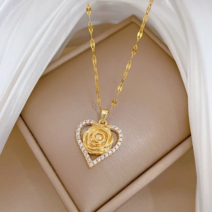 Detailed macro view of golden heart rose necklace with zircon inlay on jewelry box