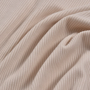 Detailed macro view of the soft beige ribbed knit fabric showing fine texture and drape