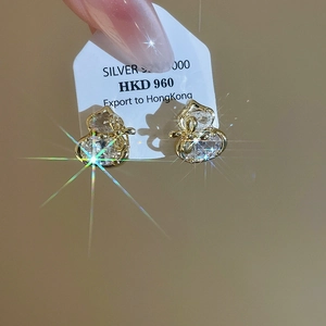 Macro shot of gold-plated S925 silver gourd earrings with sparkling zircon crystals