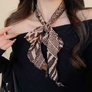 Detail of retro chiffon scarf necklace with brown animal print on black top background