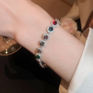 Détail d'un bracelet en argent serti de pierres multicolores et zircons sur un poignet