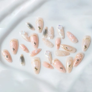 3D floral press-on nails with pearls and golden butterflies on white fabric background