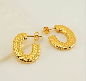 Detailed close-up of 18K gold-plated U-shaped earrings with hammered metallic texture