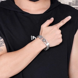 Close-up of a silver men's titanium steel chain bracelet worn on a tattooed wrist