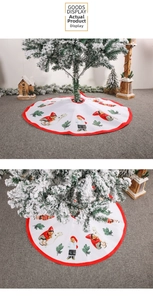 Close-up of white Christmas tree skirt with festive red piping and cute holiday illustrations