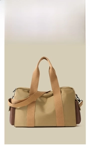 Detail view of khaki canvas and brown leather travel bag with adjustable strap