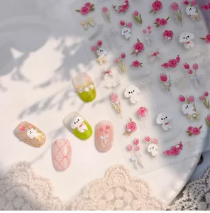 Vue macro d'autocollants 3D pour ongles avec tulipes roses et chiots blancs