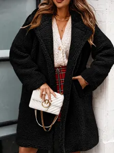 Detail of black faux shearling coat showing plush texture and wide lapel collar