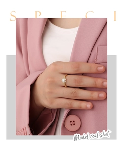 Close-up of gold heart ring with pink zircon and micro-paved diamonds on finger