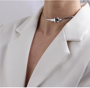 Silver belt buckle snake chain choker necklace styled on model wearing a white suit