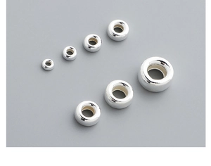 Macro shot of six assorted silver spacer beads for DIY jewelry making on gray background