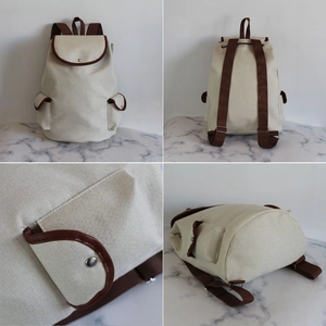 Minimalist canvas travel backpack in cream and brown with side pockets and metal snaps