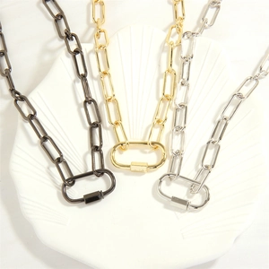 Detailed shot of gold silver and gun black chain necklaces on a white shell tray