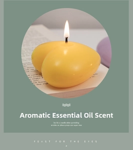 Macro shot of a yellow heart-shaped scented candle on a book with a lit wick