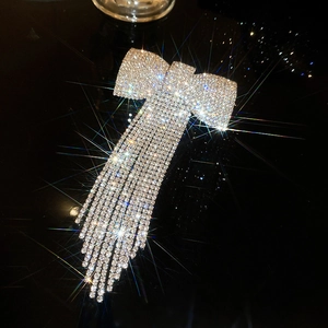 Détail d'une barrette nœud argentée avec strass scintillants et longues franges