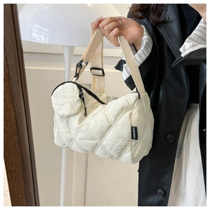 Détail du sac matelassé blanc cassé avec une petite pochette ronde et une bandoulière large