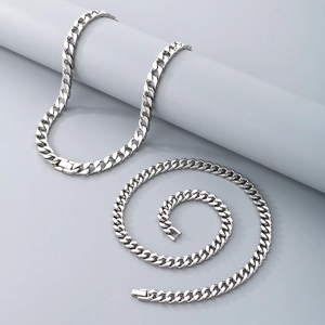 Polished silver stainless steel Cuban link necklace and bracelet set on grey display