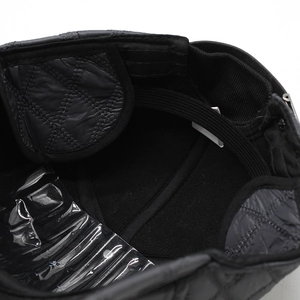 Close-up of winter hat interior featuring black quilted lining and elastic band detail