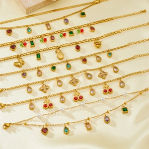 Minimalist gold chain bracelets with colorful zircon and enamel charms on beige velvet