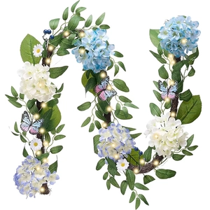 Detail of autumn wreath with blue hydrangeas, white daisies, leaves and warm LED lights