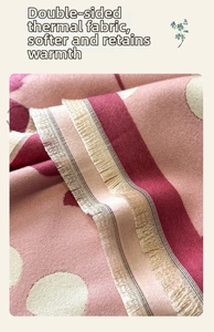Close-up of pink and burgundy cherry dot cashmere-like fabric with beige fringe details