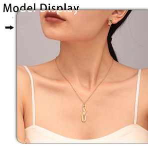Model wearing a gold infinity symbol necklace with zircon accents and matching earrings