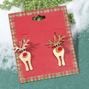 Gros plan de boucles d'oreilles renne dorées avec nez rouge sur fond de Noël festif