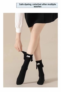 Detail of 3D doll eyes and magnetic hands on cute black cotton mid-calf socks