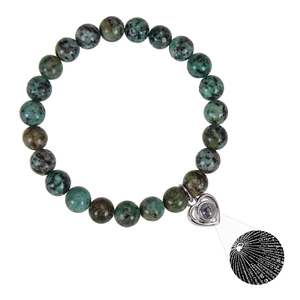 Macro shot of silver heart pendant with 100 languages projection on green stone bracelet