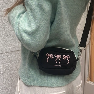 Detailansicht der schwarzen Nylon-Umhängetasche mit rosa Stickerei und Markenschrift