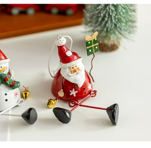 Detail of metal Santa Claus ornament with red bell body and hanging star legs