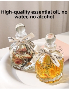 Close-up of reed diffusers with dried roses and orange slices in cut glass bottles