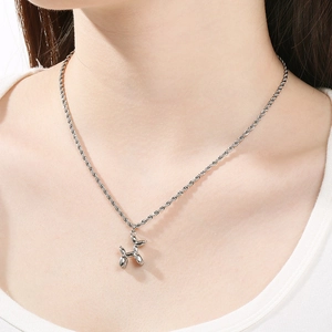 Gros plan du collier avec pendentif chien ballon argenté poli porté sur un mannequin