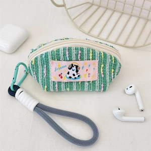 Détail de l'étui à écouteurs en maille avec écusson de chien, mousqueton et cordon bleu