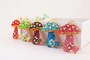 Row of colorful rhinestone mushroom keychains in pink, blue, purple, green, and red