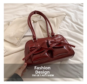 Détail d'un sac à bandoulière bordeaux à nœuds papillon en cuir verni brillant