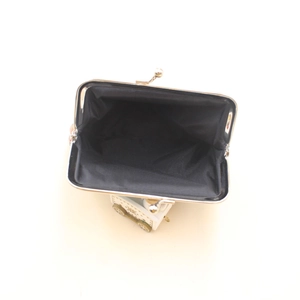 Macro shot of abstract print clip bag interior with vintage metal clasp and black lining