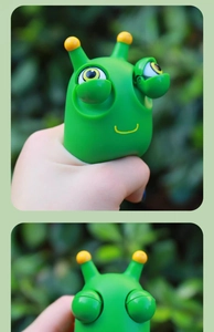 Close-up of green snail stress toy showing bulging eyes effect when squeezed by hand