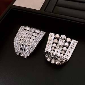 Detail shot of silver square earrings with clear rhinestones on a black jewelry tray