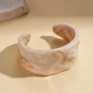 Detail view of pink marble resin open cuff bracelet with artistic pleated texture