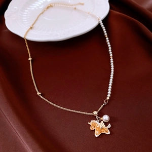 Detail of 18K gold plated unicorn pendant with pearls on red silk background