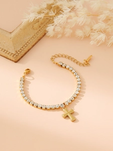 Detailed view of golden cross pendant and circular rhinestone chain with lobster clasp