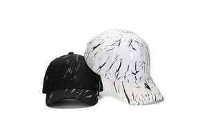 Detail of baseball caps in black and white with artistic ink splatter pattern texture
