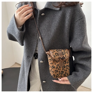 Détail du sac bandoulière léopard avec boucle en corne vintage sur manteau en laine